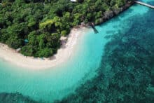 Aerial image of Green Island showing tropical rainforest, white sandy beach and turquoise reef water.
