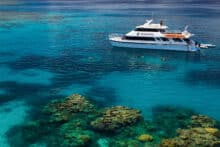 Poseidon snorkel and dive boat anchored above clear turquoise water at the Agincourt Ribbon Reefs near Port Douglas.