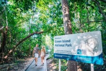 Couple walking along the rainforest boardwalk at Green Island National Park.