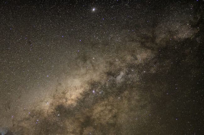 Milky Way galaxy filled with a billion stars glowing above the Great Barrier Reef at night.