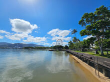 The Cairns Ferris Wheel and waterfront viewed from the Esplanade on a clear tropical day.