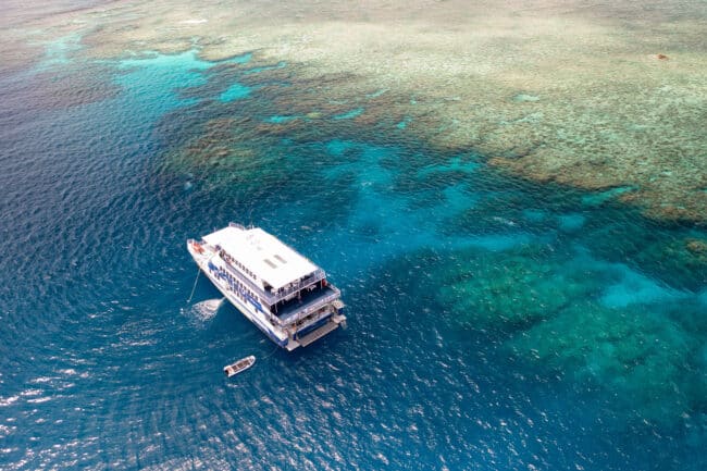 Aerial view of OceanQuest liveaboard and day vessel near the coral edge of the Great Barrier Reef.