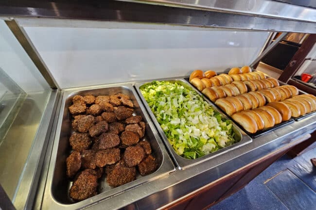Buffet counter with lettuce, burgers & rolls prepared for lunch aboard OceanQuest Cairns.