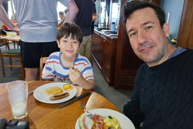 Father & son enjoying breakfast together aboard OceanQuest liveaboard on the Great Barrier Reef.
