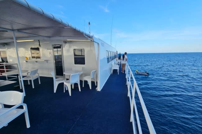 OceanQuest liveaboard anchored on the Great Barrier Reef under clear blue skies.