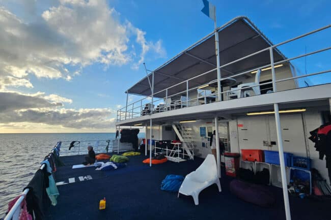 Rear sundeck of OceanQuest liveaboard with deck chairs overlooking the Coral Sea.