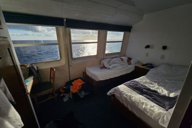 Twin-share cabin on OceanQuest liveaboard with large ocean-view windows overlooking the reef.