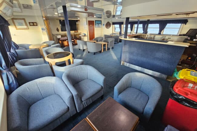 OceanQuest indoor lounge and bar area with seating and a large flat-screen TV.