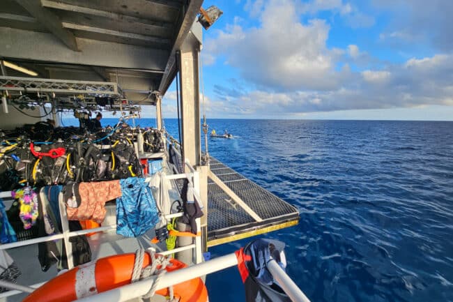 OceanQuest deck view at sunset with guests enjoying the horizon.