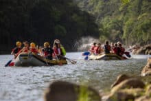 Rafting groups paddling across the calm waters of Lake Placid at the end of their Barron River rafting tour.