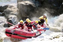 Rafting team plunging into Rooster Tail Rapid on the Barron River in Cairns.
