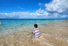 Child playing at the shoreline on a crystal clear beach at Green Island on the Great Barrier Reef