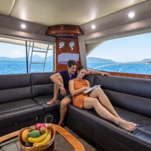 Guests relaxing inside the main saloon of Allure private yacht on the Great Barrier Reef
