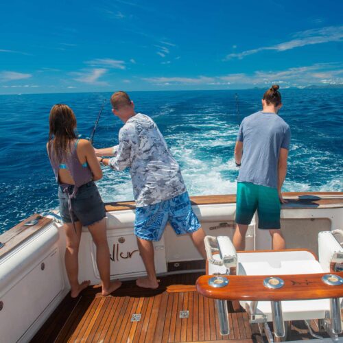 Guests fishing from the back deck of Allure private charter yacht near Cairns