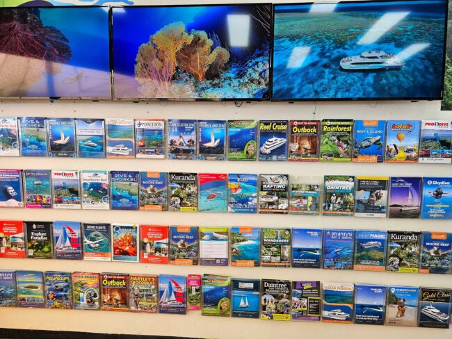 Great Barrier Reef tour brochures displayed inside Cairns Dive Adventures booking centre