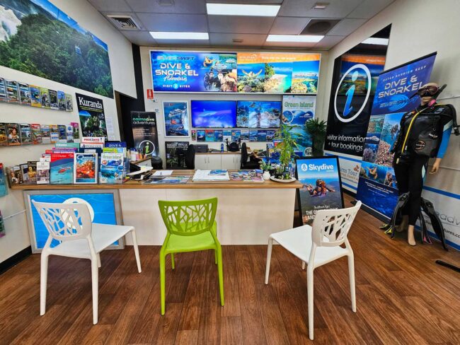 Inside Cairns Dive Adventures booking centre with reef tour displays and travel desk