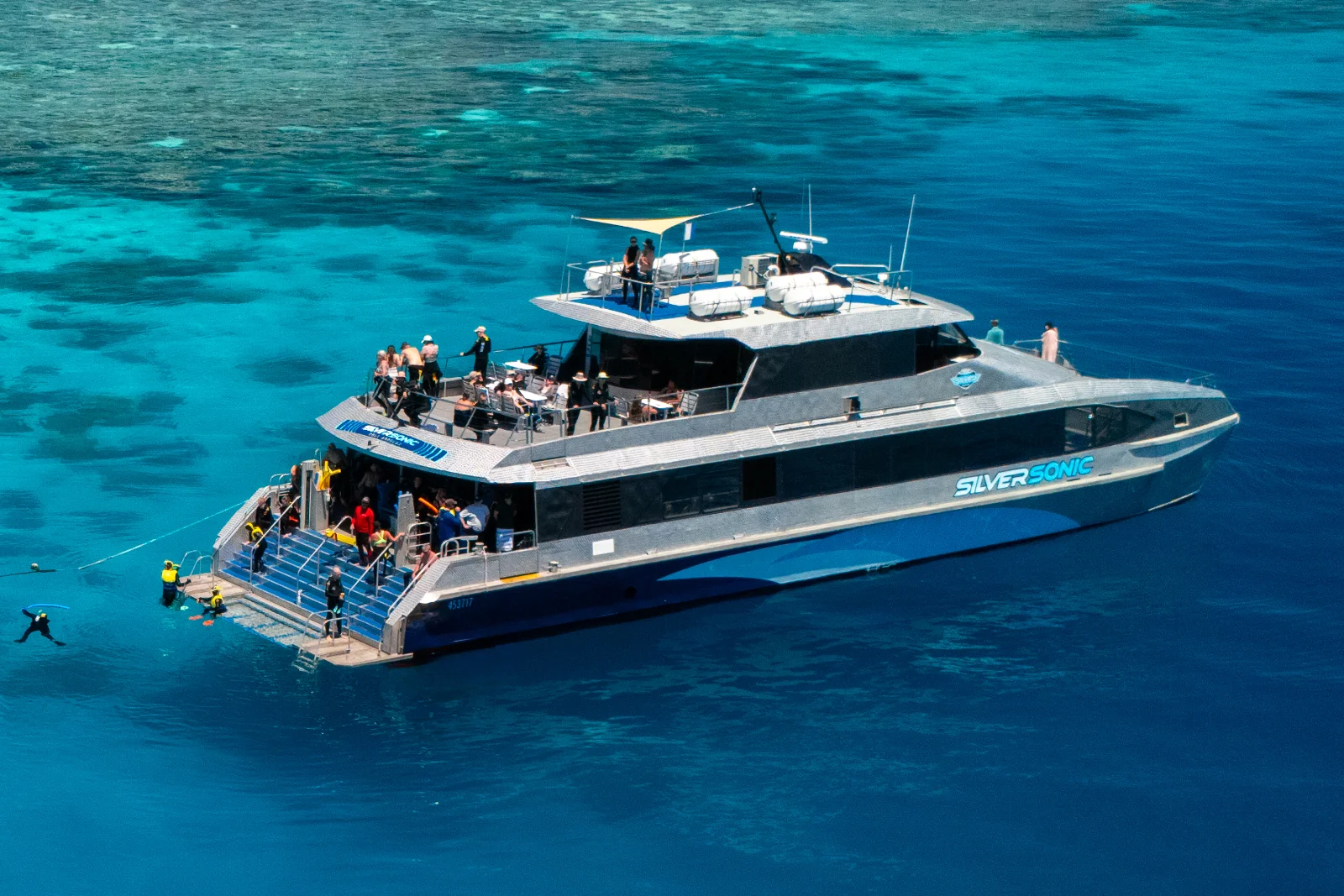 Silversonic dive and snorkel catamaran anchored over clear blue water at the Agincourt Ribbon Reefs near Port Douglas.