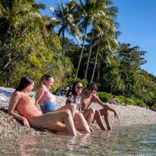 Group of friends relaxing by the water on Fitzroy Island beach