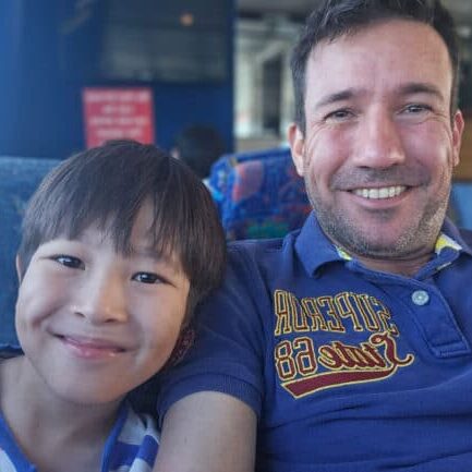 oceanquest-liveaboard-father-son Father and son smiling on board the OceanQuest transfer vessel departing Cairns.